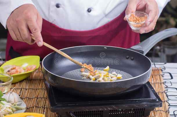 厨师把萝卜干片放到锅里
