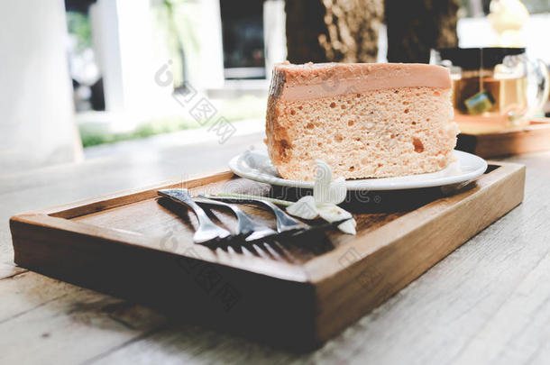 餐盘上的蛋糕，用叉子和花在木桌上的复古色调。