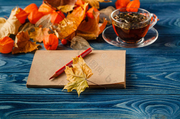 木桌上的空白记事本和五颜六色的秋天枫叶