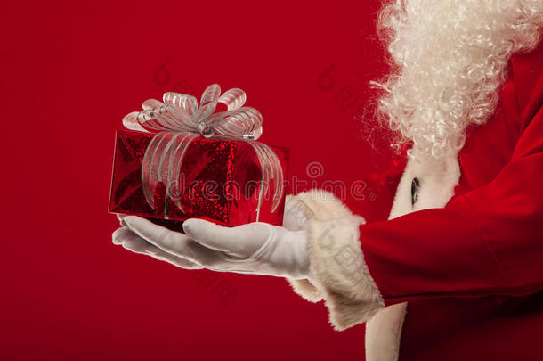 圣诞照片圣诞老人戴着手套的手和<strong>礼品</strong>盒，在一个<strong>红色</strong>的<strong>背景</strong>上