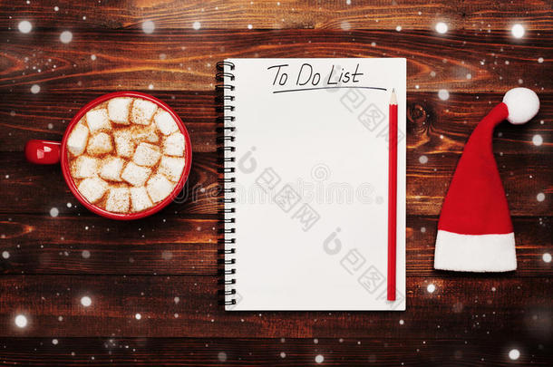 一杯热可可或巧克力，棉花糖，圣诞帽和笔记本，从上面做清单，圣诞节计划。