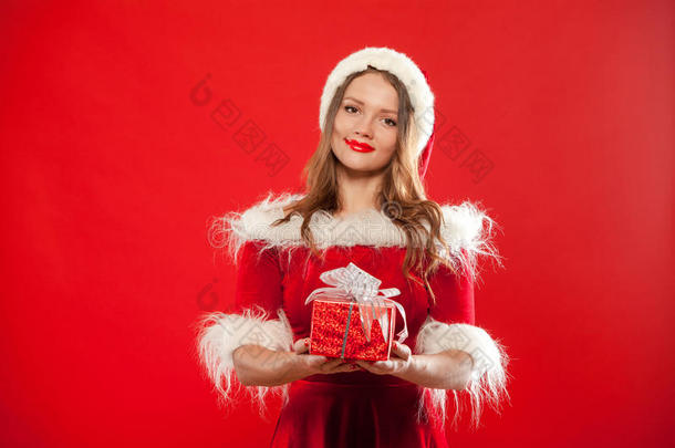 <strong>圣诞</strong>节，<strong>圣诞</strong>节，冬天，幸福的概念-微笑的女人戴着<strong>圣诞</strong>老人的帽子，带着礼品盒，<strong>红色背景</strong>