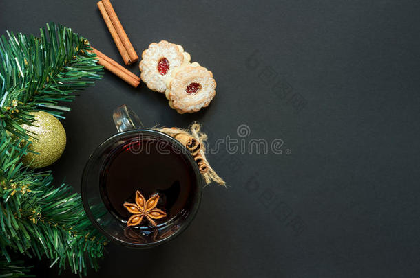 圣诞树和酒杯的覆盖葡萄酒与饼干和橙色的黑色桌面视图