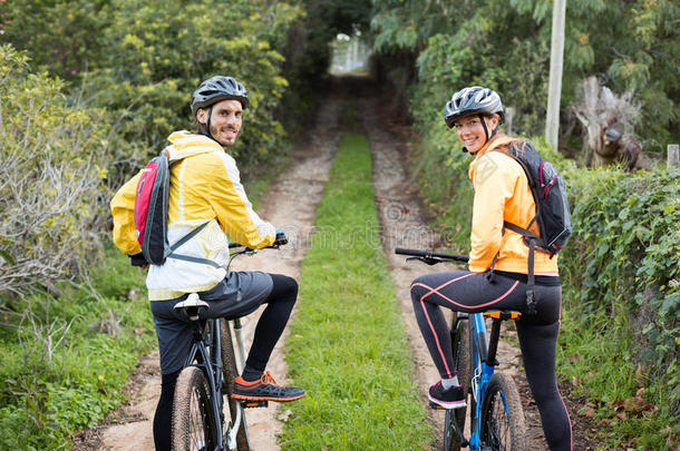 骑自行车的夫妇在乡村赛道上骑山地车