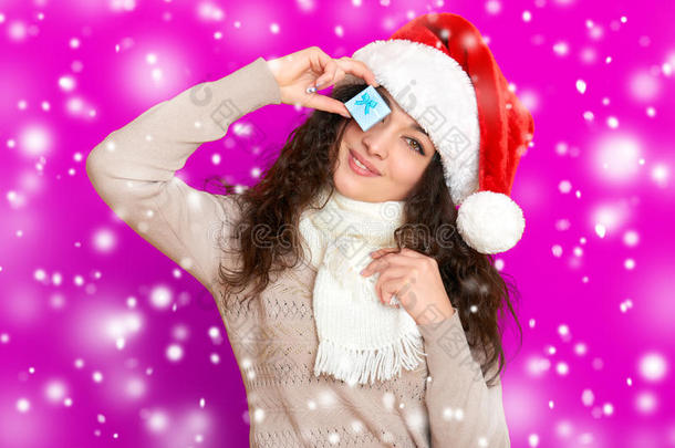 女孩在圣诞帽肖像与<strong>小礼品</strong>盒摆在粉红色背景，圣诞节假期的概念，快乐和情感
