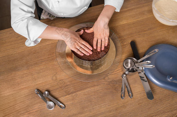 巧克力蛋糕准备在厨房桌子上与厨房用具，顶部视图
