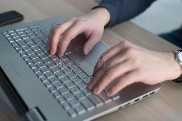 双手在笔记本电脑键盘上打字。 在工作场所工作的人