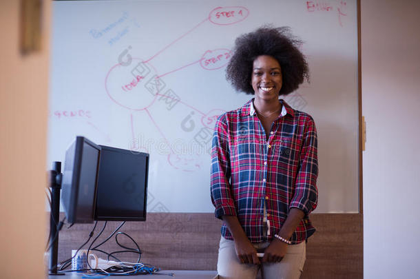 一位非洲裔美国妇女<strong>在</strong>现代办公室的<strong>黑板上写字</strong>