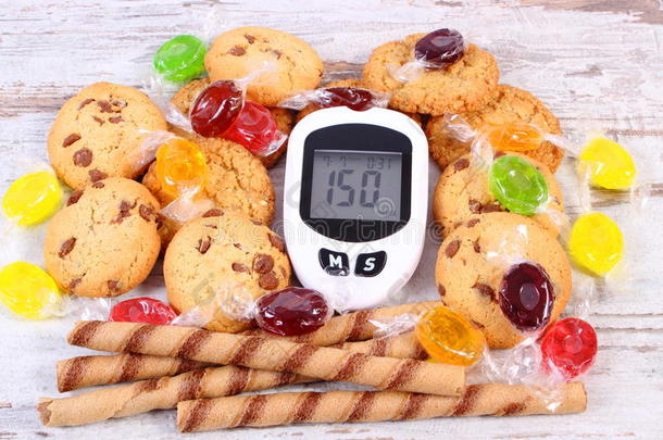 血糖仪和彩色糖果与饼干，糖尿病，减少吃糖果