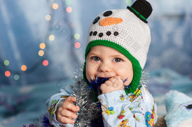 宝贝在圣诞雪人手里拿着节日装饰品，