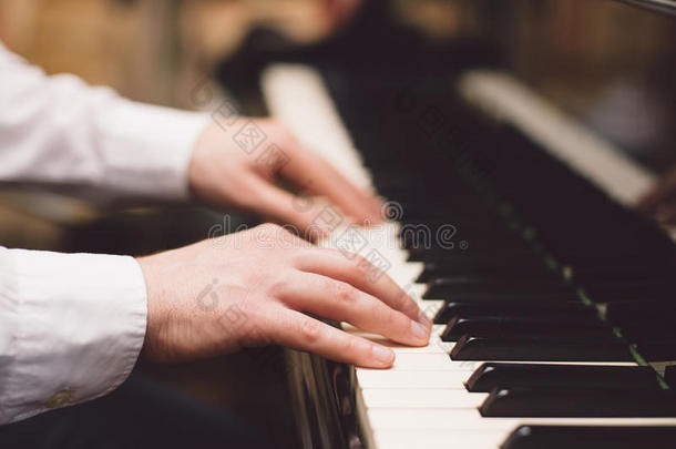 音乐表演者演奏钢琴的手的特写