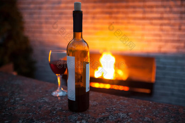 瓶和一杯背景有火的红酒；