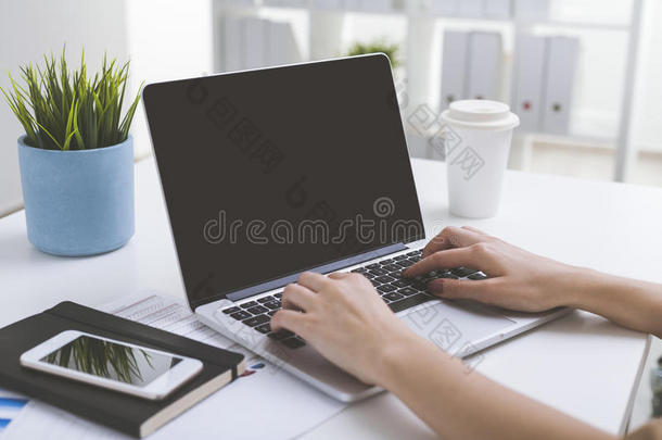 关闭笔记本电脑屏幕，女人的手在键盘上
