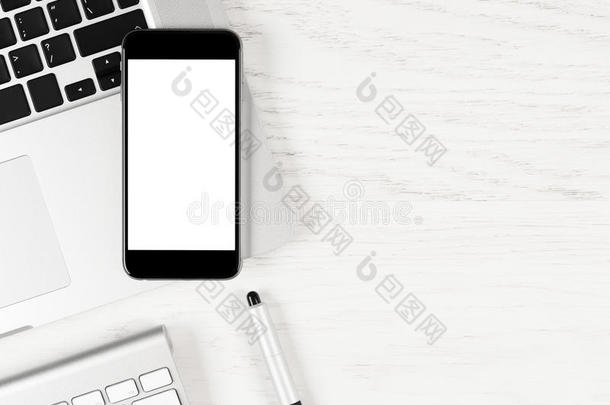 黑色智能手机，空白屏幕躺在白色桌子上的<strong>银色笔记本</strong>电脑上