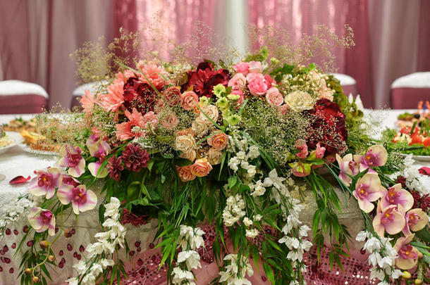 美丽的白色婚礼拱门装饰粉红色和红色的花朵户外