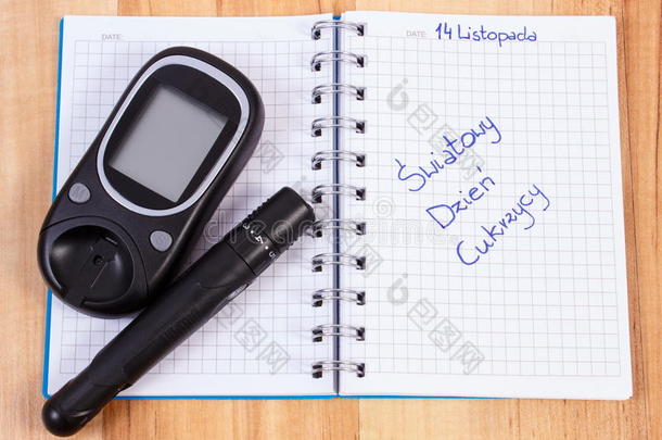 血糖仪与柳叶刀装置和波兰铭文世界糖尿病日在笔记本上