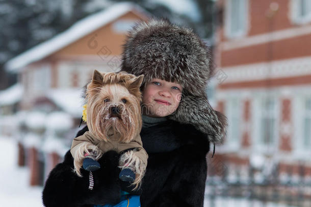 戴着毛皮帽子的女孩，<strong>冬天</strong>，<strong>霜冻</strong>的下午，和他心爱的狗约克郡猎犬散步