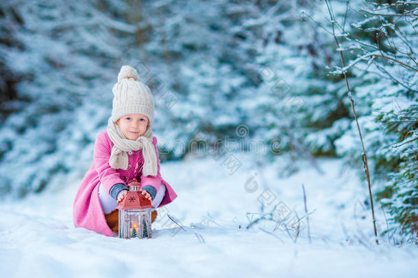 可爱的小女孩穿着<strong>温暖</strong>的外套，在圣诞节的户外用手电筒<strong>温暖</strong>冰冷的手