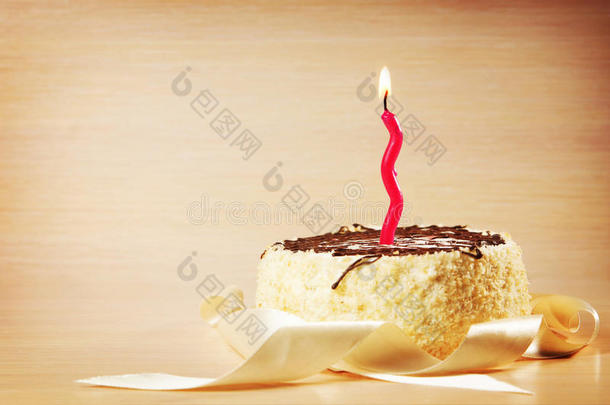生日蛋糕和一支装饰燃烧的蜡烛