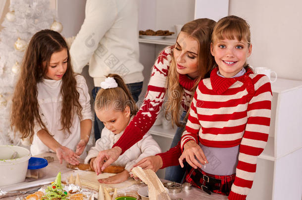 一家人带着孩子在圣诞节的厨房里擀面团。