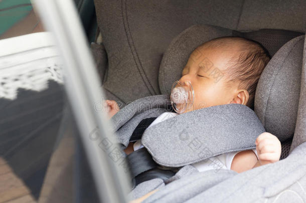 亚洲可爱的新生婴儿睡在现代汽车<strong>座椅</strong>上。