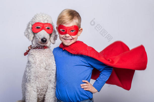 英俊的<strong>小超人</strong>带着狗。 超级英雄。 万圣节。 白色背景下的工作室肖像