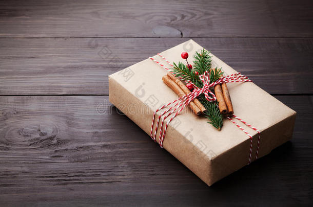 礼品或礼物盒，用<strong>牛皮纸包装</strong>，并在老式木桌上装饰圣诞装饰。 复制文本空间。
