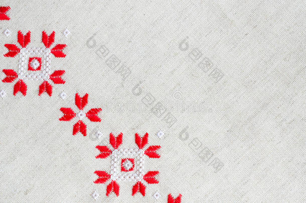 红色和白色棉线在亚麻上的元素手工刺绣。 刺绣背景。