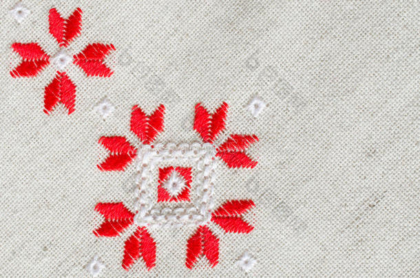 亚麻上红色和白色棉线的刺绣设计。 带有刺绣的圣诞节背景。
