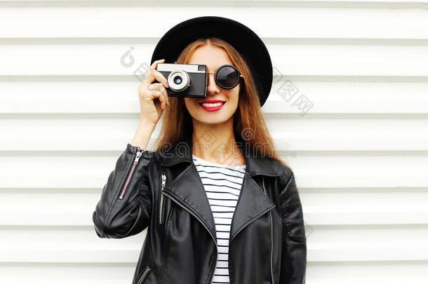 时尚的外观，相当酷的年轻女子模特与<strong>复古胶卷</strong>相机戴着优雅的帽子，皮革岩石夹克白色