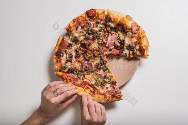 女人的手和披萨在盘子里