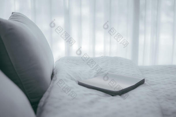 一本书，位于床上，舒适的软枕头，老式过滤器，放松的概念。