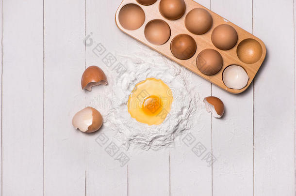 鸡蛋在面粉里。 制作面团背景。 用生鸡蛋、糖、面粉、牛奶烘焙
