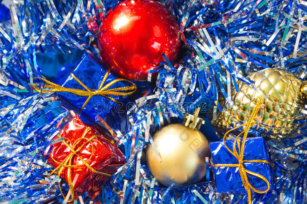 圣诞装饰品特写照片。 红色和金色的球。 金松。 蓝色和红色包裹的礼物。