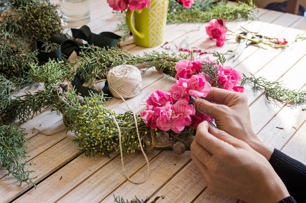 工作中的花店：用花创造一个木制的花环。 圣诞节