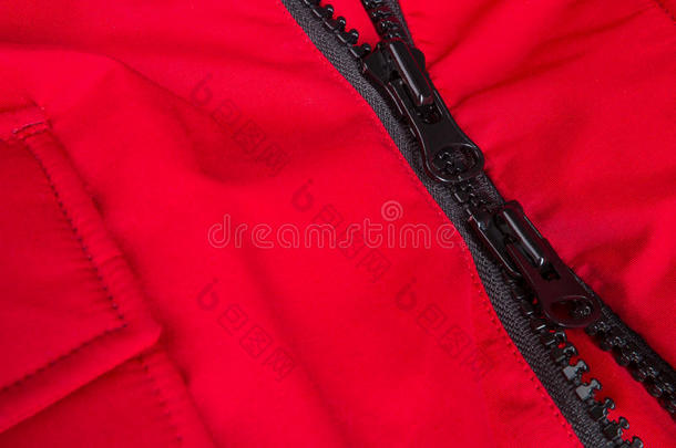 红色夹克和黑色拉链的碎片。 拉链背景。 关门。