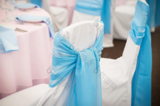 餐厅里带丝带和蝴蝶结的椅子。 婚礼