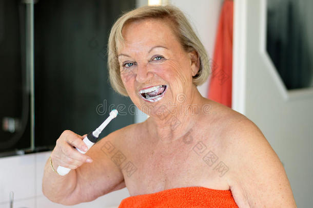 老年妇女使用<strong>电动牙刷</strong>