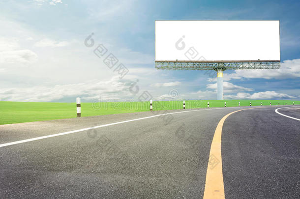 空白广告牌为您的广告与文字的空间在道路曲线，绿色的草和蓝天背景。