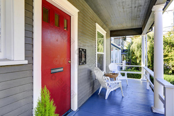 入口门廊有白色柱子，蓝色木地板，红色门