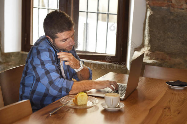 在咖啡店吃早餐时使用笔记本电脑的商人或学生