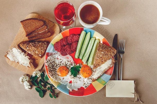 美味可口的早餐，从鸡蛋，面包与黄油，香肠在彩色盘子。咖啡，红色果汁与白色的花。愿望的汽车