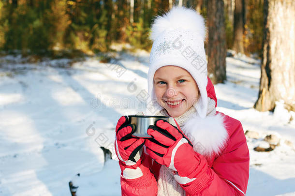孩子在森林里的热水瓶里喝茶