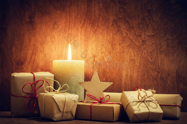圣诞礼物，蜡烛在木墙背景上发光的礼物。
