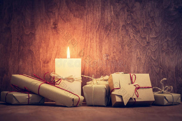 圣诞礼物，蜡烛在木墙背景上发光的礼物。