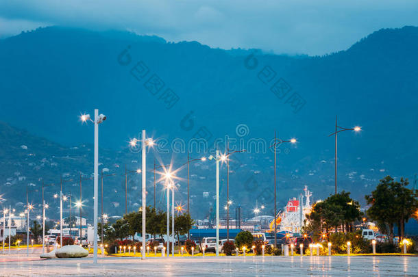 巴统乔治亚在码头穿过一排排发光的灯柱。 傍晚<strong>雾霾背景</strong>下的山景。