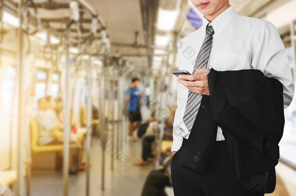 商务办公室员工在地铁或天空列车上使用智能<strong>手机</strong>，在<strong>日</strong>出的早晨上班