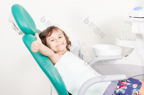 可爱的小女孩微笑着在牙科诊所显示OK标志