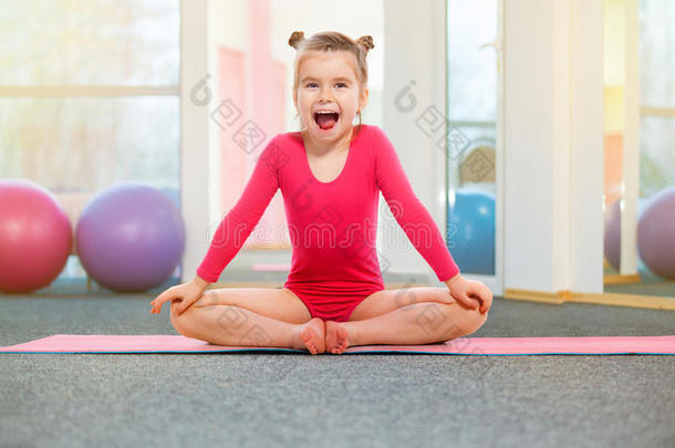 可爱的小女孩体操运动员在健身房。 运动，训练，健身观念