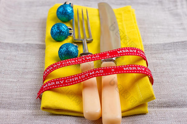 圣诞节<strong>新年背景</strong>。 把叉子，刀，勺子放在黄色餐巾上，装饰节日金丝带，<strong>蓝色</strong>球